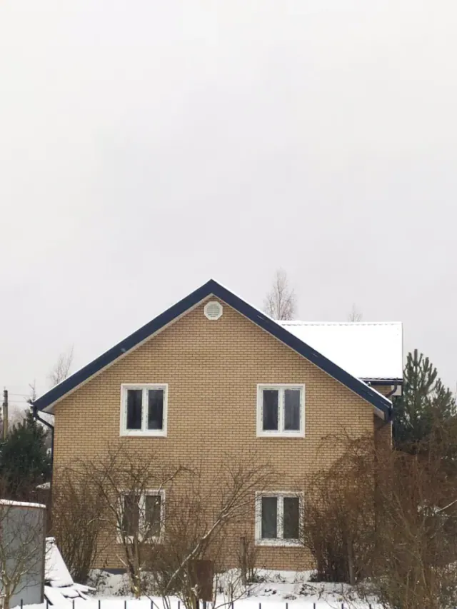 Торцевой фасад двухэтажного дома с окнами